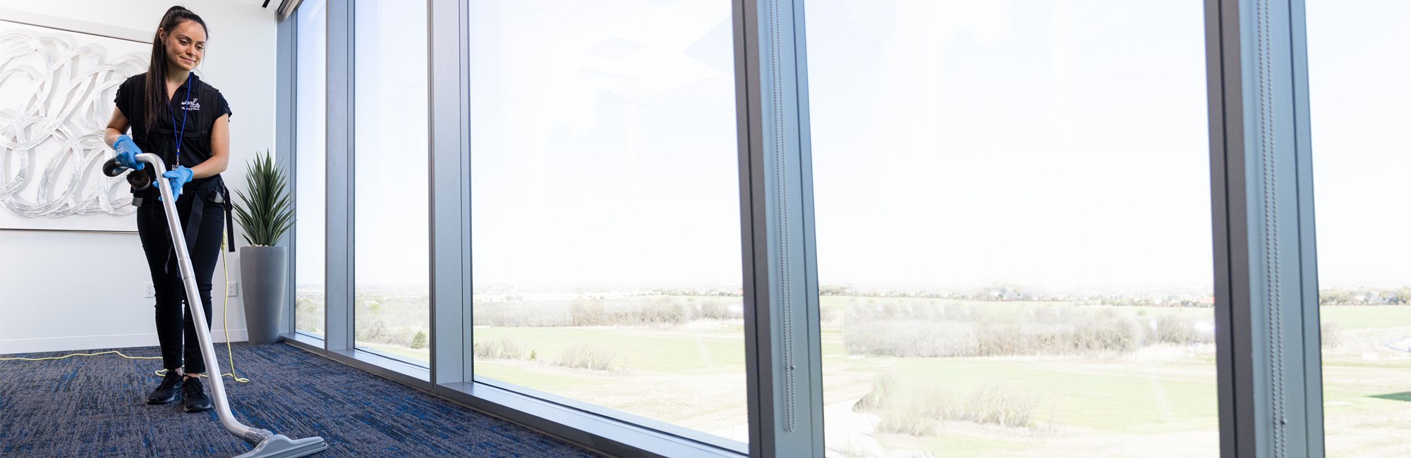 a woman in a room with a vacuum and a painting