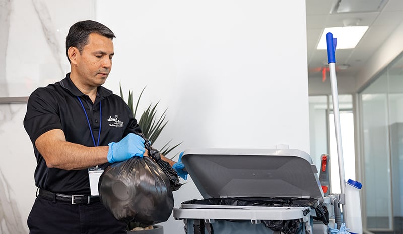 a man wearing a black shirt taking out the trash