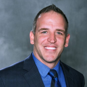 a man in a suit and tie smiling