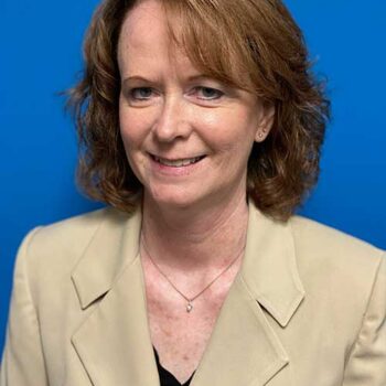 a woman in a suit and tie sitting at a table