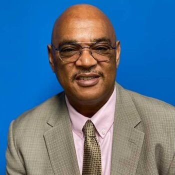 a man in a suit and tie sitting on a chair