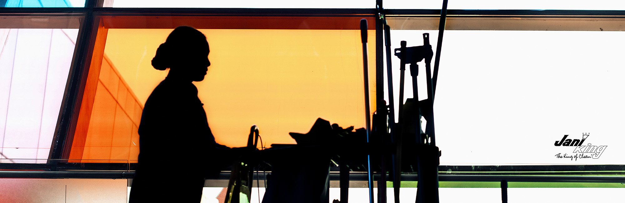 Cleaning personnel walking with cleaning supplies through a medical building.
