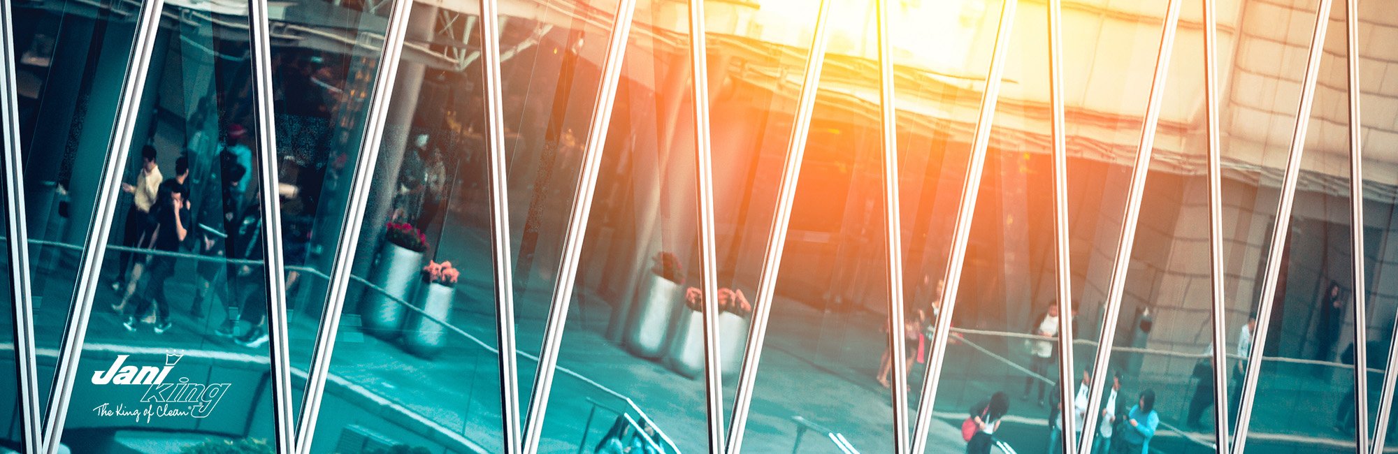 Sun reflecting off windows while shoppers walk around in the background.